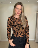 Blusa de tule caramelo com estampa floral em alto relevo preto, vista frontal com mangas longas e parte superior ajustada